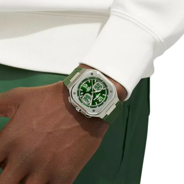 montre bell & ross chronographe vert acier portée par un homme à la peau foncée vêtu d'un pull blanc et d'un pantalon vert
