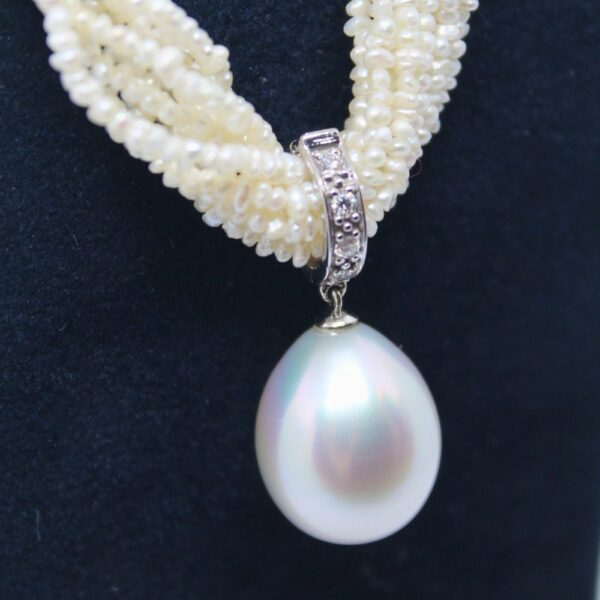 zoom sur collier perles blanches, or blanc, diamant et perle goutte centrale en pendentif